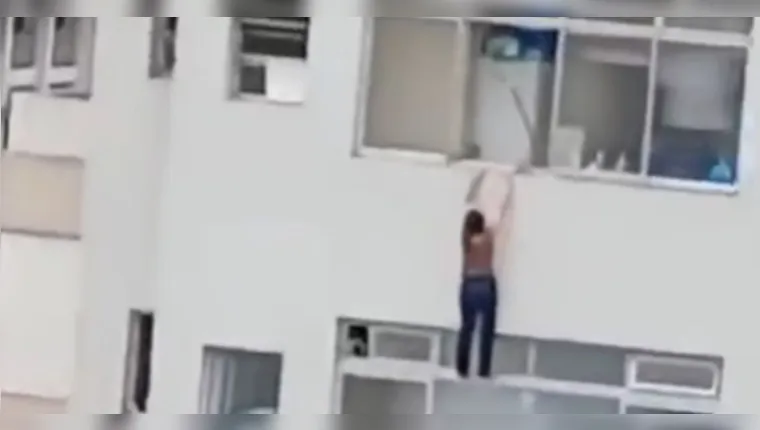 Imagem chocante: mulher fica pendurada em janela